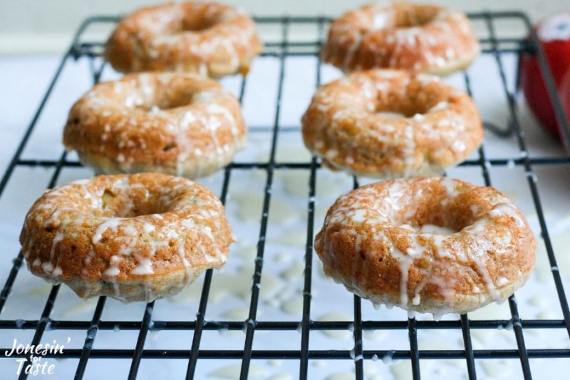 Closeup of 6 BAKED CINNAMON APPLE DOUGHNUTS on a wire rack
