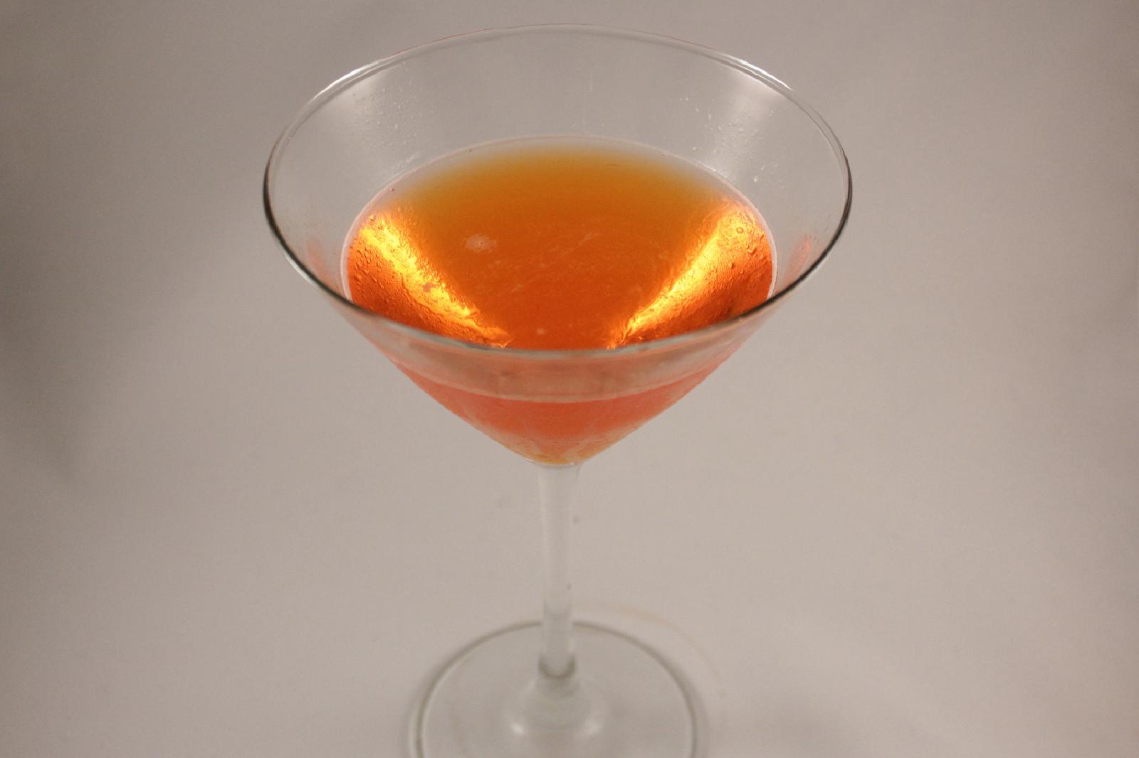 orange-pink Comtesee d'Italia cocktail on white background