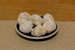 Several white chocolate lemon truffles on a small plate