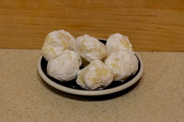 Several white chocolate lemon truffles on a small plate